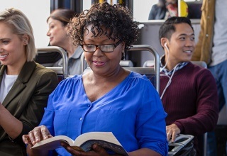 woman reading a book while riding the bus